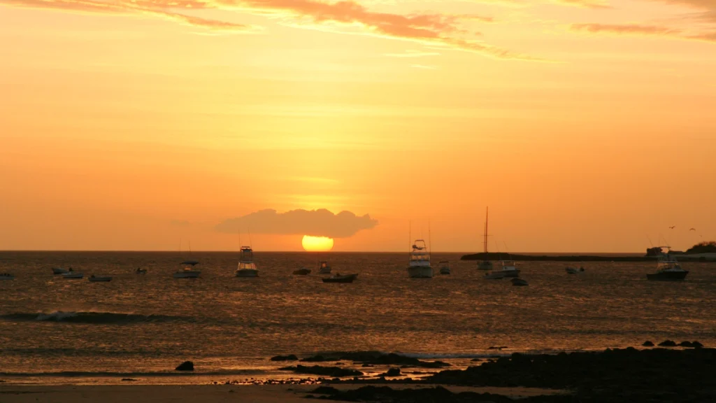 Sunset over the ocean with sailboats in Tamarindo Costa Rica